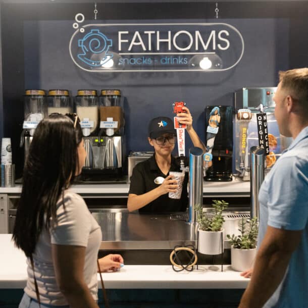 Employee pouring a beer for customers at the Fathoms dining option at Texas State Aquarium
