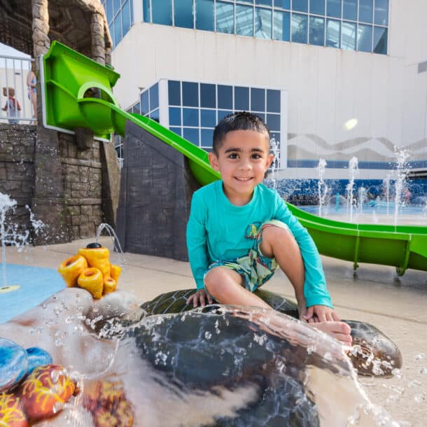 Picture of a small boy enjoying the Splash Pad at the Texas State Aquarium